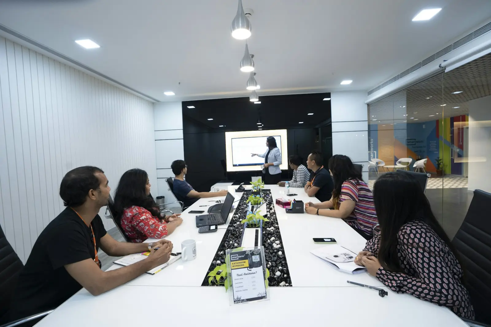 A facilitator leading a working session with a team around a meeting table
